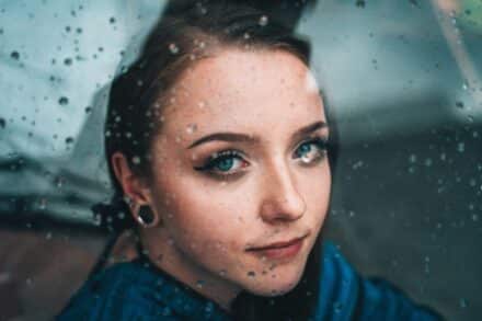 young woman wearing blue shirt and hair tied back